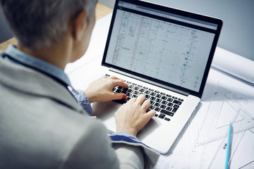 High angle view of female architect using laptop at table in office