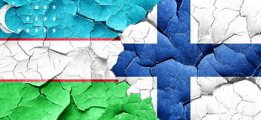 Uzbekistan flag with Finland flag on a grunge cracked wall