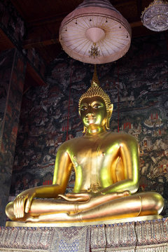 golden buddha statue with thai painting background