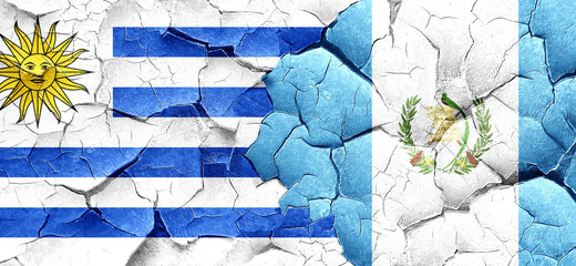 Uruguay flag with Guatemala flag on a grunge cracked wall