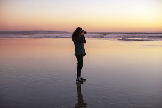 Woman photographing on beach