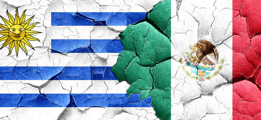 Uruguay flag with Mexico flag on a grunge cracked wall