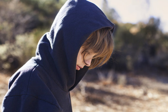 Boy in hooded jacket walking outdoors
