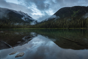 Calm and Peaceful view with the reflection on the lake during a cloudy sunset. Taken at Joffre Lake, BC, Canada.