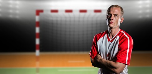 Portrait of volleyball player with arms crossed against digital image of handball goal 