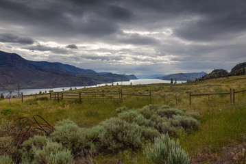 Obraz premium View of the field and a distant river surrounded by mountains. Taken on my recent road trip in British Columbia, Canada.