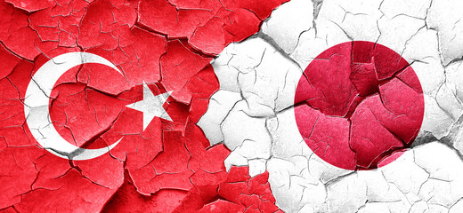 Turkey flag with Japan flag on a grunge cracked wall
