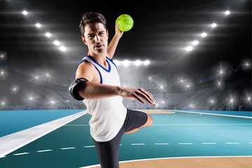 Portrait of athlete man throwing a ball  against handball field indoor 