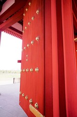 金鋲の打たれた朱塗りの門