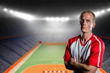 Portrait of volleyball player with arms crossed against handball field indoor 