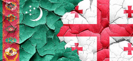 Turkmenistan flag with Georgia flag on a grunge cracked wall