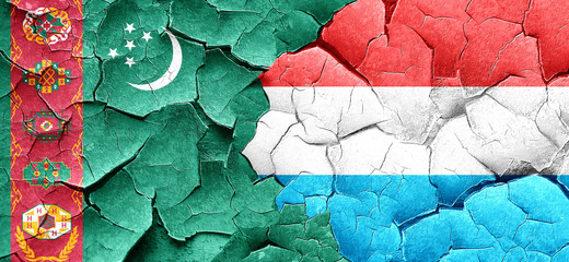 Turkmenistan flag with Luxembourg flag on a grunge cracked wall