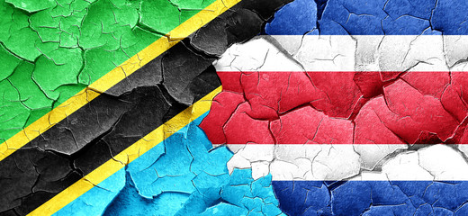 Tanzanian flag with Costa Rica flag on a grunge cracked wall