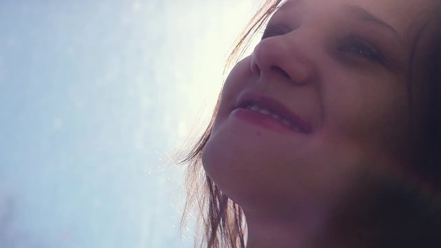 Girl doing bubble with chewing gum on the sky bacground with the sun and lensflare in slowmotion. 1920x1080