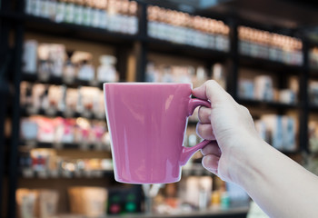Woman hand holding coffee cup on blurred background