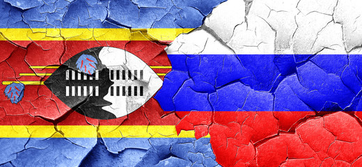 Swaziland flag with Russia flag on a grunge cracked wall