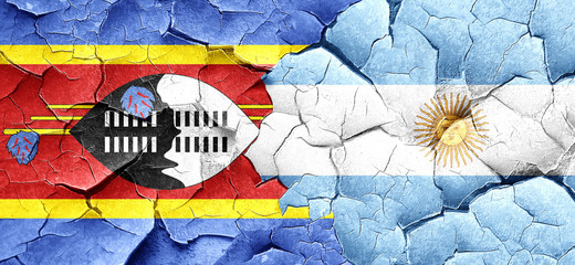 Swaziland flag with Argentine flag on a grunge cracked wall