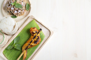 grilled chicken wings with steamed glutinous rice on banana leaf