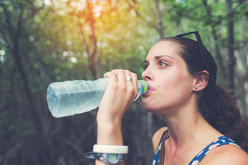 young hiker drinking water at Mangrove forest, Thailand