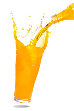 Pouring orange juice from bottle into glass with splashing., Isolated white background.