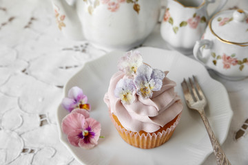 purple cupcakes with  sugared edible flowers on vintage plate.