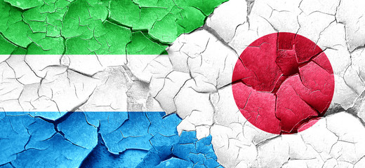 Sierra Leone flag with Japan flag on a grunge cracked wall