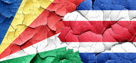 seychelles flag with Costa Rica flag on a grunge cracked wall