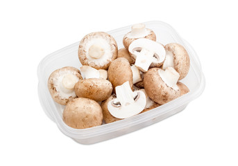 Button mushrooms in a plastic tray on a light background
