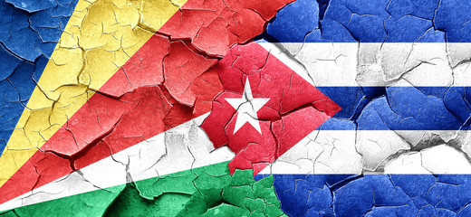 seychelles flag with cuba flag on a grunge cracked wall