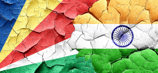 seychelles flag with India flag on a grunge cracked wall