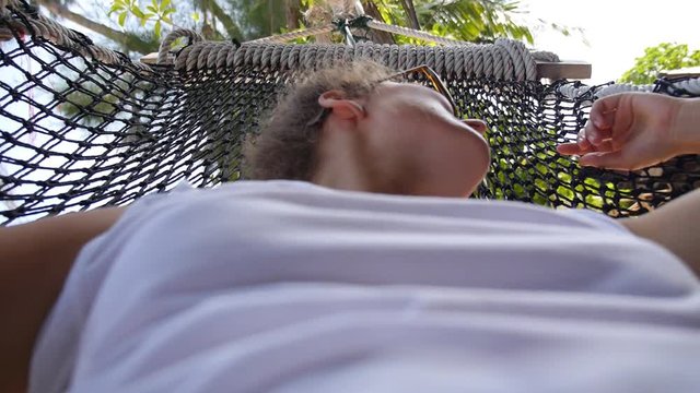 Sexy Girl Relaxing in Hammock on Beach in Summer Holiday