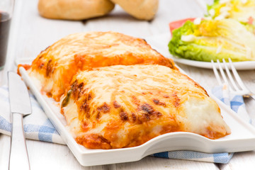lasagna baked in porcelain tray on wooden