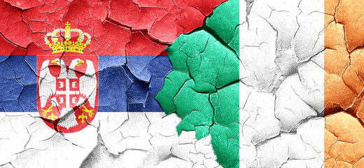 Serbia flag with Ireland flag on a grunge cracked wall