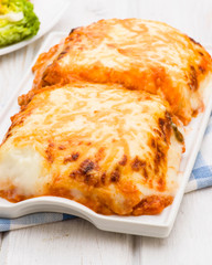 lasagna baked in porcelain tray on wooden