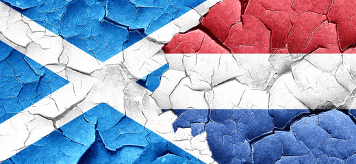 scotland flag with Netherlands flag on a grunge cracked wall