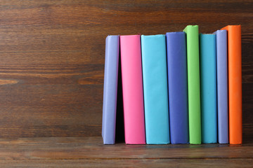 a stack of books in beautiful covers on wooden background