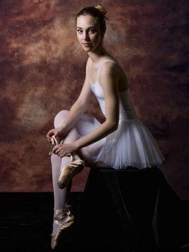 Portrait of a ballerina putting her pointe shoes