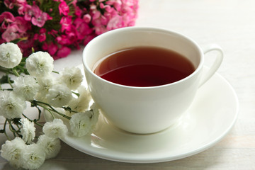 bouquets of chrysanthemum with a Cup of tea on white wooden background
