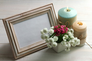 a bouquet of chrysanthemum with wooden frame for photo on wooden background with candles