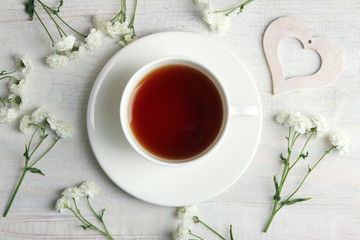 white decorative hearts with  flowers on white wooden background with Cup of tea