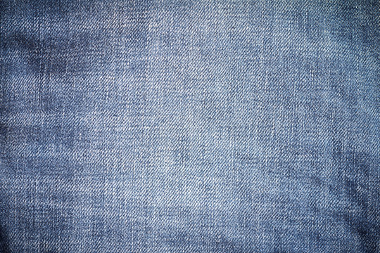 Closeup denim jeans texture. Stitched textured blue denim jeans background. Old grunge vintage denim jeans. Denim jeans fashion design.