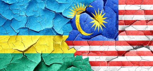 Rwanda flag with Malaysia flag on a grunge cracked wall