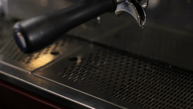 Barista picks up two cups of fresh made espresso. Close up