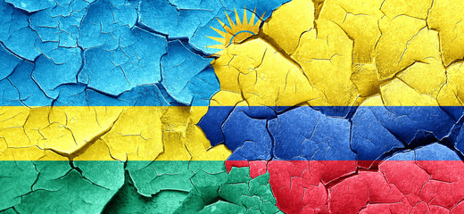 Rwanda flag with Colombia flag on a grunge cracked wall