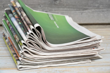Close-up of a stack of colored papers on a wooden table background
