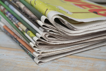 Close-up of a stack of colored papers on a wooden table background
