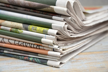 Close-up of a stack of colored papers on a wooden table background
