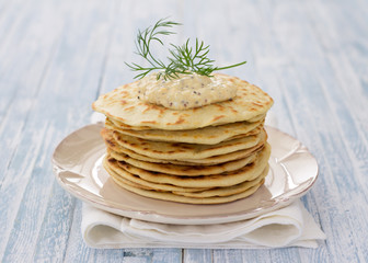 Flat bread with egg dip and dill on a blue wooden background, selective focus