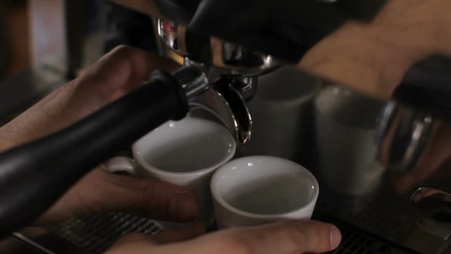 Barista prepares two cups of espresso. Close up