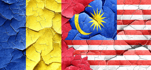 Romania flag with Malaysia flag on a grunge cracked wall